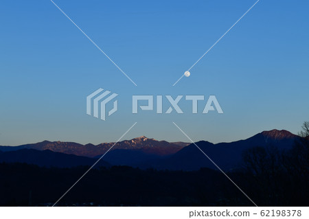 Full moon rising when the mountains of Okuchichibu are illuminated by afterglow (Takegawa Town, Hokuto City) (Mt. Full moon rising when the mountains of Okuchichibu are illuminated by afterglow (Takegawa Town, Hokuto City) (Mt. 62198378