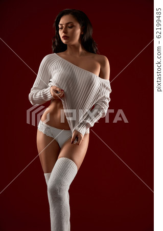 Sexy model posing in sweater and underwear. 62199485