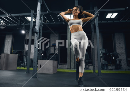Fitnesswoman posing in gym. 62199584