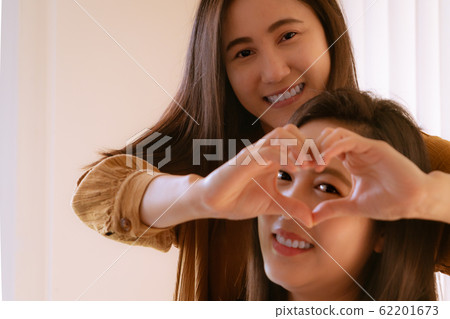 Happy Woman Day. two beautiful Woman friends Holding Heart Shaped Hands. Healthy Eyes And Vision. Happy Woman Day. two beautiful Woman friends Holding Heart Shaped Hands. Healthy Eyes And Vision. 62201673