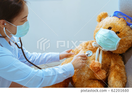 Doctor and patient. Physician examining brown bear wearing mask against virus and flu 62201680