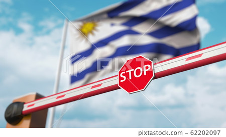Closed boom barrier with stop sign against the Uruguayan flag. Restricted entry or certain ban in Uruguay. 3D rendering 62202097