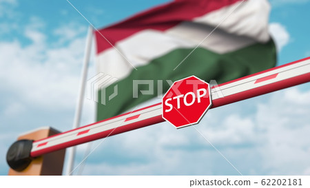 Closed boom gate on the Hungarian flag background. Restricted entry or certain ban in Hungary. 3D rendering 62202181