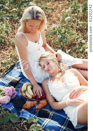 Mother with beautiful daughter in a autumn field 62202242
