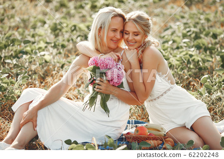 Mother with beautiful daughter in a autumn field Mother with beautiful daughter in a autumn field 62202248