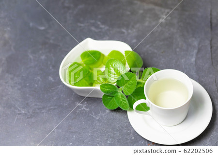 Cup of Silver Spurflower tea on stone slate plate. 62202506