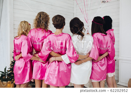 Bridesmaids in pink silk robes with the word 62202952