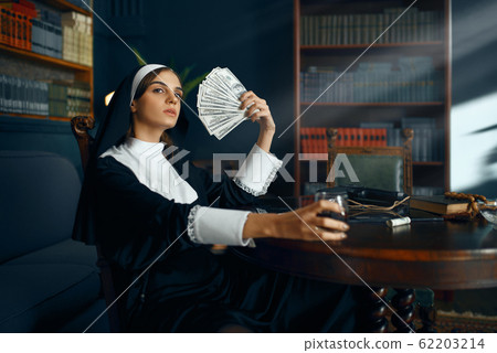 Sexy nun in a cassock holding a fan of dollars Sexy nun in a cassock holding a fan of dollars 62203214