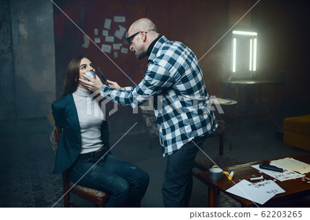 Maniac kidnapper taping his victim's mouth shut 62203265