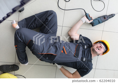 Severe pain in back builder, man lies on floor. Severe pain in back builder, man lies on floor. 62204010