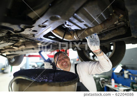 Mechanic conducts thorough inspection car garage. Mechanic conducts thorough inspection car garage. 62204086