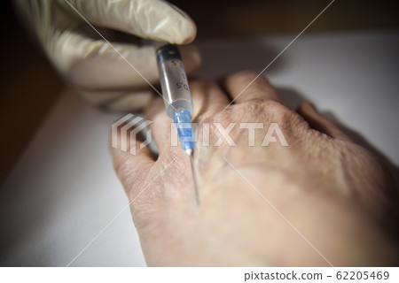 Hand in the medical glove with syringe preparing 62205469