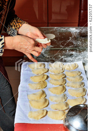 Woman spreads the finished raw dumplings Woman spreads the finished raw dumplings 62205737