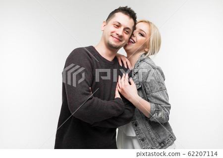 charming caucasian girl licked her lover's ear on a light gray background charming caucasian girl licked her lover's ear on a light gray background 62207114