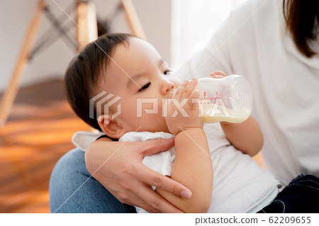 Asian mother feeding a male baby with milk bottle Asian mother feeding a male baby with milk bottle 62209655