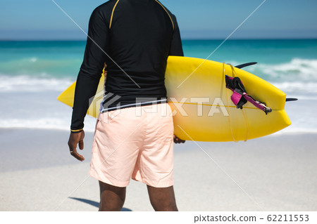 Old man carrying a surfboard Old man carrying a surfboard 62211553