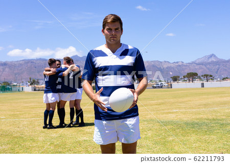 Rugbymen standing with ball 62211793