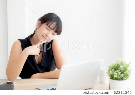 Beautiful freelance young asian woman thinking and idea working laptop computer at office 62211845