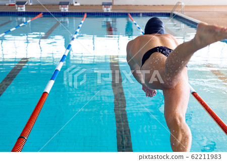 Swimmer plunging in the pool 62211983