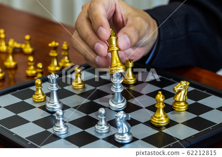 Chess game on chess board behind business man 62212815