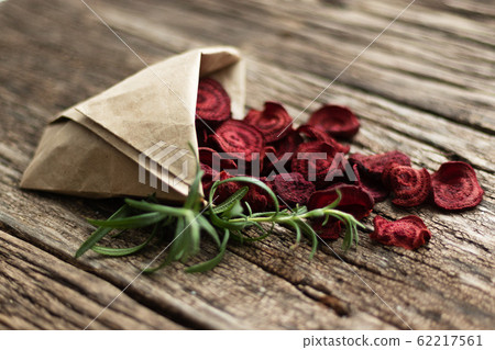 Homemade beetroot chips. Snacks are wrapped in a paper bag. Handmade healthy vegetable chips. Natural healthy snack 62217561