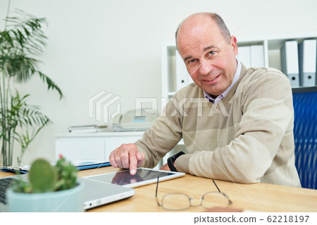 Mature entrepreneur using tablet computer Mature entrepreneur using tablet computer 62218197