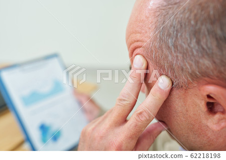 Tired businessman analyzing charts Tired businessman analyzing charts 62218198