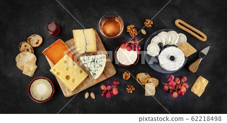 Cheese variety panorama with wine and fruit, a flat lay, overhead shot on a black background Cheese variety panorama with wine and fruit, a flat lay, overhead shot on a black background 62218498