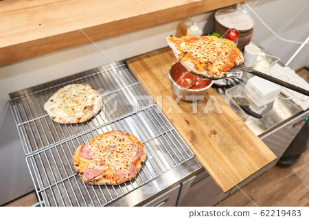 Pizza Margarita Heart-shaped for Valentine's day.. Baked tasty margherita pizza in Traditional wood oven in Neapolitan restaurant, Italy. Pizza Margarita Heart-shaped for Valentine's day.. Baked tasty margherita pizza in Traditional wood oven in Neapolitan restaurant, Italy. 62219483