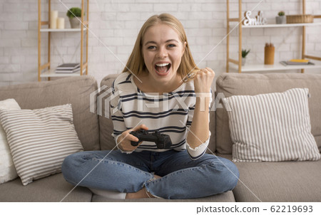 Emotional young woman playing video games at home 62219693