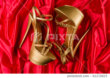 golden strip high heels on red satin background golden strip high heels on red satin background 62219825
