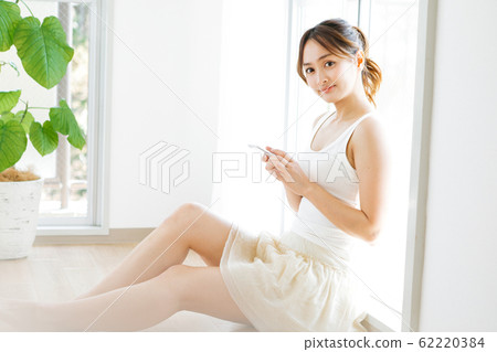 A woman using a smartphone A woman using a smartphone 62220384