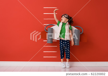 child is playing superhero 62220802