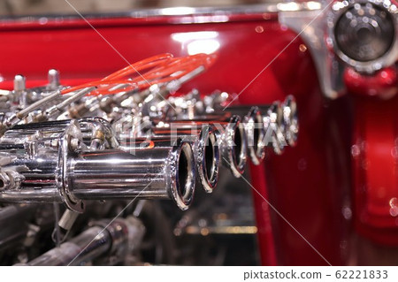 Shiny chrome exhaust on red hot rod engine 62221833