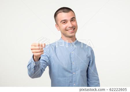 Gimme geture. Young hispanic man doing fist bump on white studio shoot 62222605