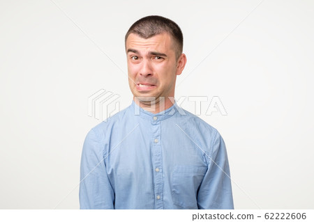 Funny young hispanic man showing cynical unhappy angry face Funny young hispanic man showing cynical unhappy angry face 62222606