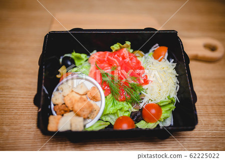 Caesar salad with red fish, crackers, tomatoes and cheese 62225022