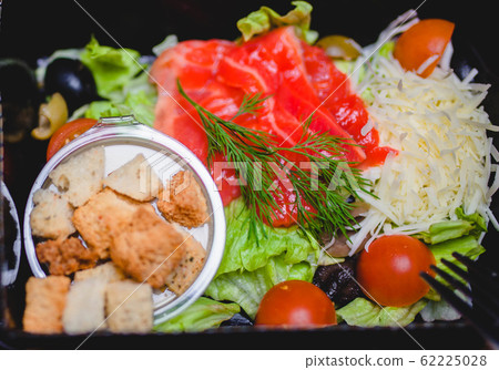 Caesar salad with red fish, crackers, tomatoes and cheese 62225028