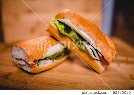 Buratta cheese sandwich and tomatoes on a wooden board 62225030