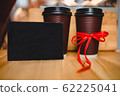 Two plastic coffee cups with a black plate 62225041