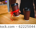 Two plastic cups of coffee with a lid on a wooden background 62225044