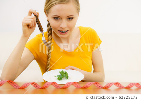 Woman on diet holding plate with lettuce Woman on diet holding plate with lettuce 62225172
