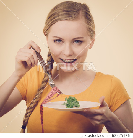 Woman on diet holding plate with lettuce Woman on diet holding plate with lettuce 62225176
