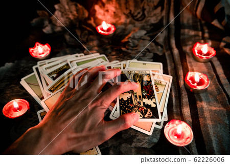 Hand on tarot card with candlelight on the 62226006