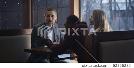 Young man showing smartphone to businessman Young man showing smartphone to businessman 62226283