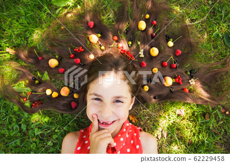 Happy girl think about healthy food lay on the grass Happy girl think about healthy food lay on the grass 62229458