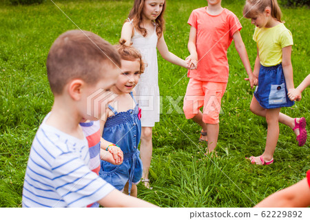 Joyful kids dancing holding hands in summer park Joyful kids dancing holding hands in summer park 62229892