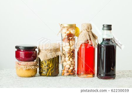 Homemade sauce, seasoning and berry syrup on white table. 62230039