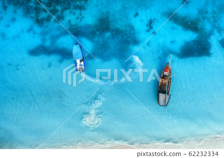 Aerial view of the fishing boats in clear blue sea at sunset in summer. Top view from drone 62232334