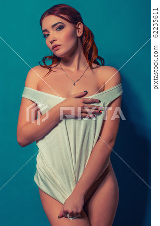 sexy red-haired girl in a t-shirt on a blue sexy red-haired girl in a t-shirt on a blue 62235611